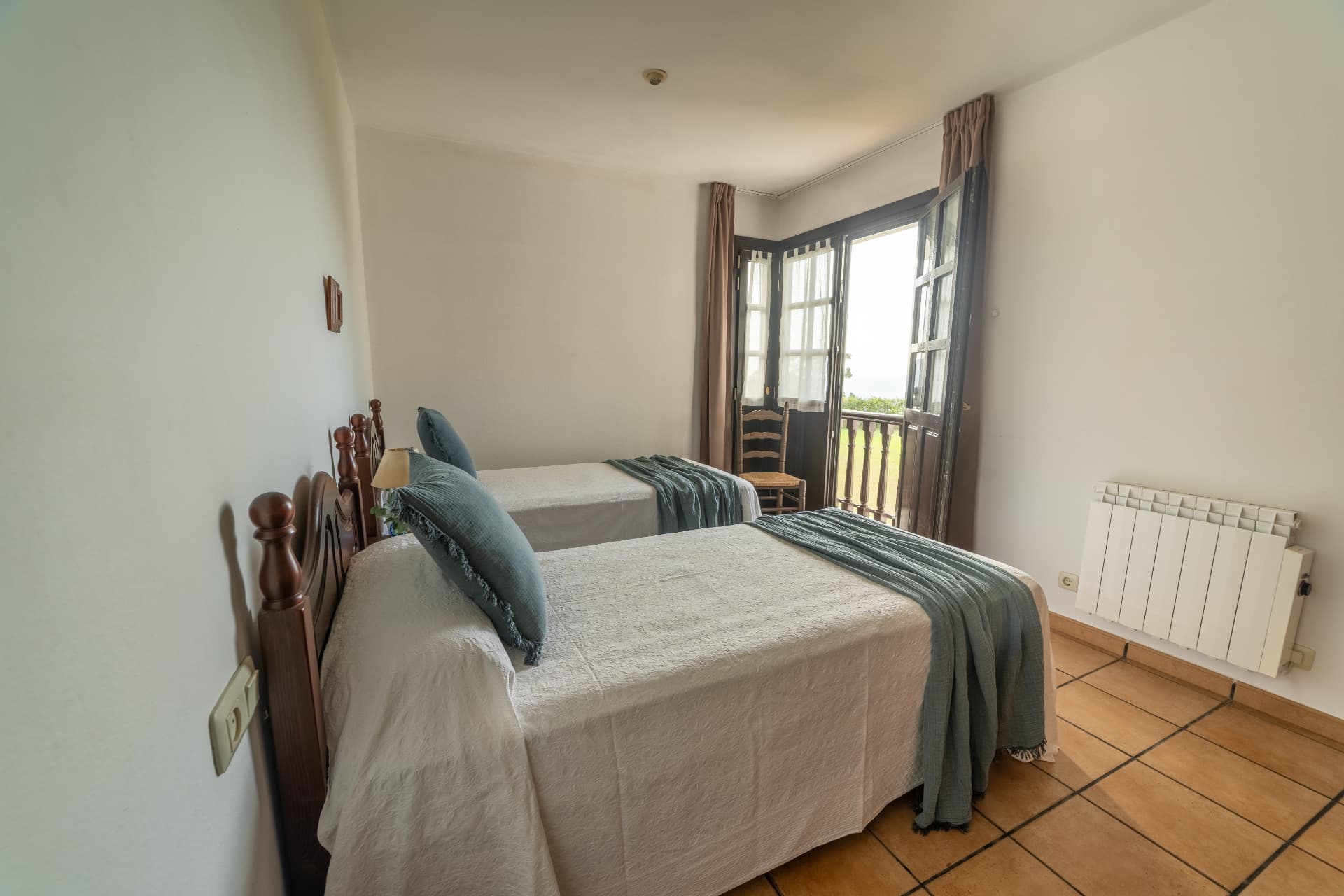 Dormitorio con dos camas y balcón