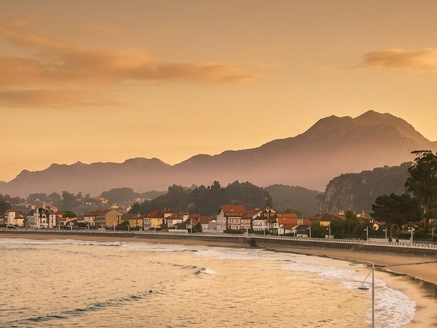 Playa de Santa Marina y la bahía de Ribadesella al atardecer, con los Picos de Europa al fondo