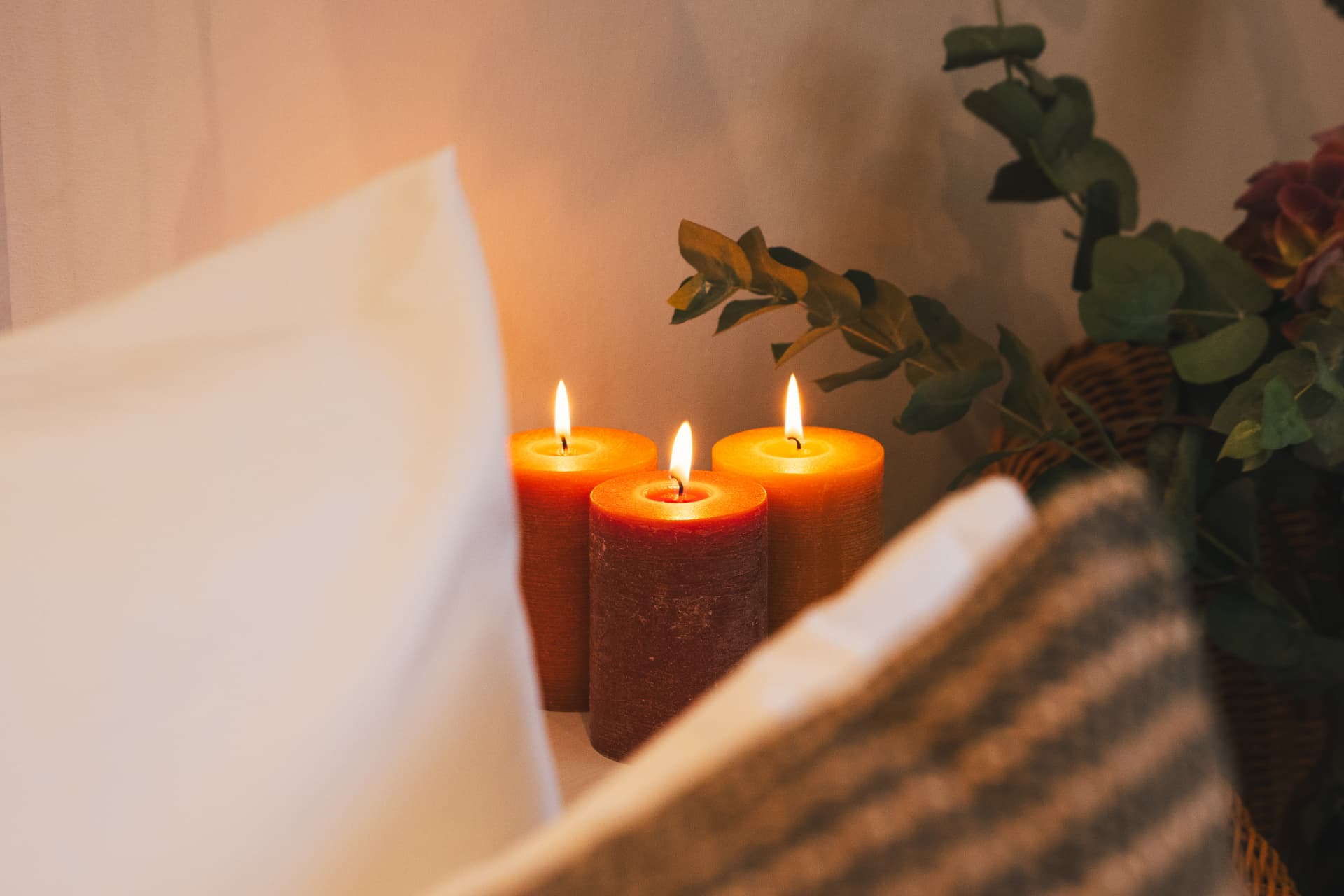 Detalle de velas encendidas junto a la ropa de cama