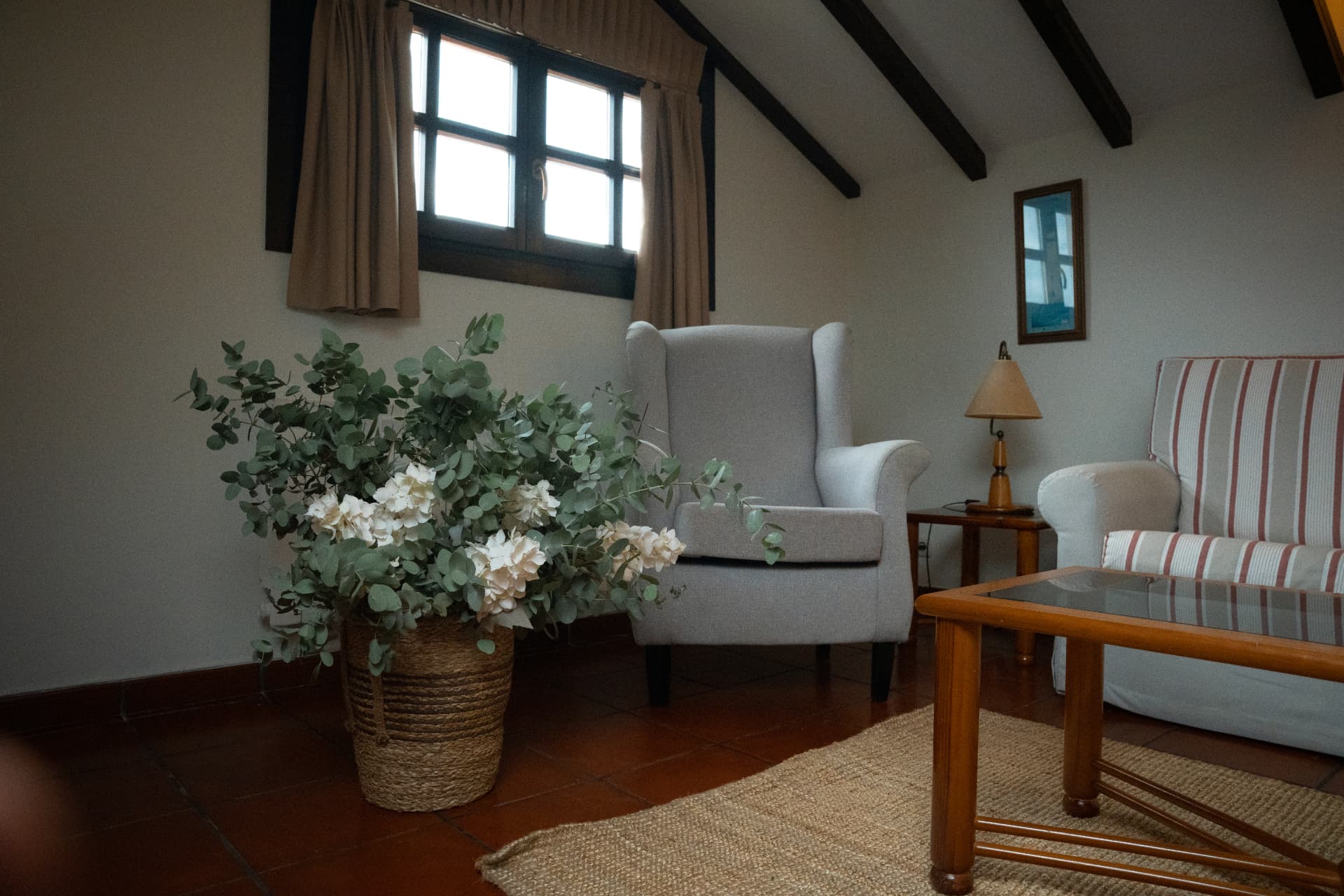 Salón abuhardillado con vigas de madera en apartamento de tres dormitorios